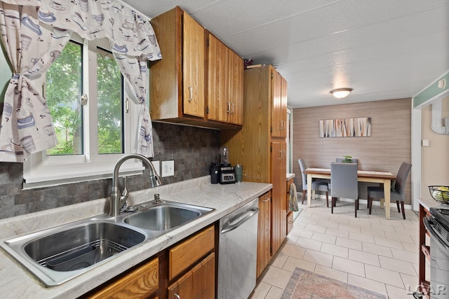 311 Marion St, Clinton, MI 49236 - kitchen featuring dishwasher, a sink, light countertops, brown cabinetry, and wooden walls