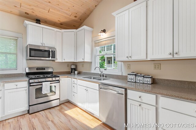 2338 Crescent Walk, Macatawa, MI 49434 - kitchen with stainless steel appliances, a sink, white cabinets, wood ceiling, and lofted ceiling