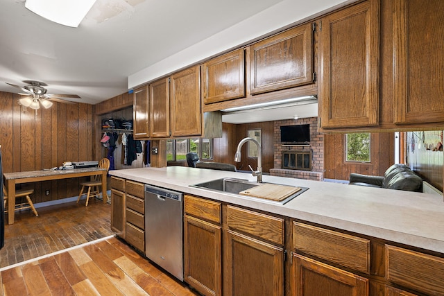 3618 Grape Ave NE, Grand Rapids, MI 49525 - kitchen with stainless steel dishwasher, a sink, light countertops, plenty of natural light, and wood walls