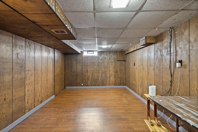3618 Grape Ave NE, Grand Rapids, MI 49525 - below grade area with wood-type flooring, wooden walls, baseboards, and a paneled ceiling