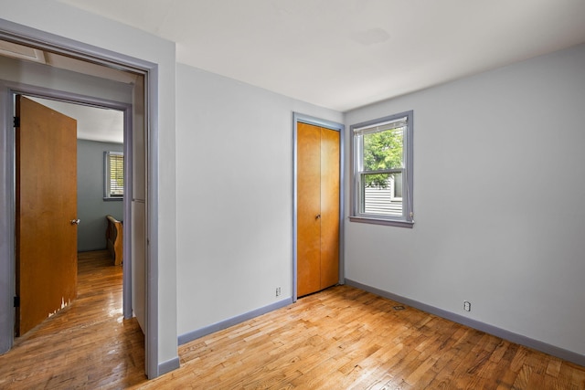 3618 Grape Ave NE, Grand Rapids, MI 49525 - unfurnished bedroom featuring light wood-style floors, a closet, baseboards, and multiple windows