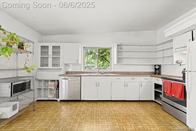 219 Beaver St, Brighton, MI 48116 - kitchen featuring stainless steel appliances, open shelves, white cabinetry, and a sink