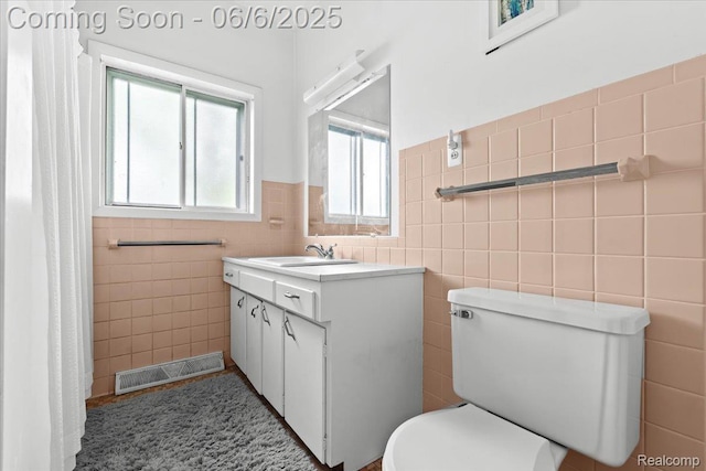 219 Beaver St, Brighton, MI 48116 - full bathroom featuring tile walls, vanity, toilet, and a wainscoted wall
