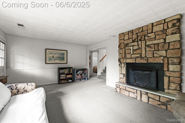 219 Beaver St, Brighton, MI 48116 - living room featuring carpet, a stone fireplace, wainscoting, and stairs