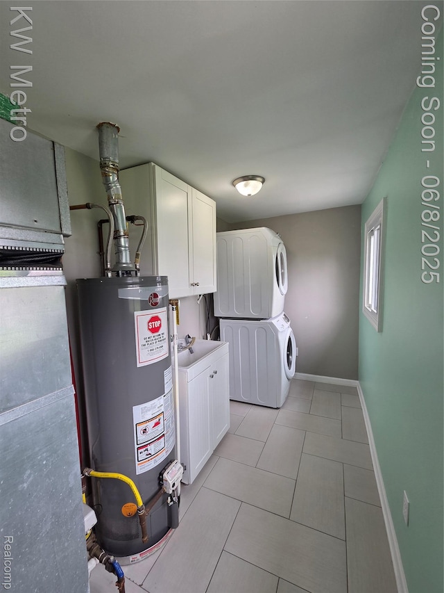 23328 Harding Ave, Hazel Park, MI 48030 - washroom featuring stacked washer / dryer, water heater, baseboards, light tile patterned floors, and cabinet space