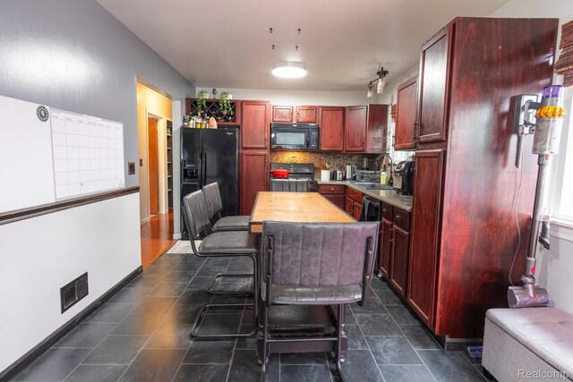 23400 Reynolds Ave, Hazel Park, MI 48030 - kitchen featuring black appliances, reddish brown cabinets, light countertops, a sink, and decorative backsplash