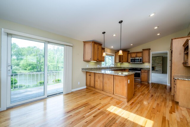 2310 Riverbend Dr, Benton Harbor, MI 49022 - kitchen with appliances with stainless steel finishes, light wood-type flooring, a peninsula, brown cabinets, and vaulted ceiling