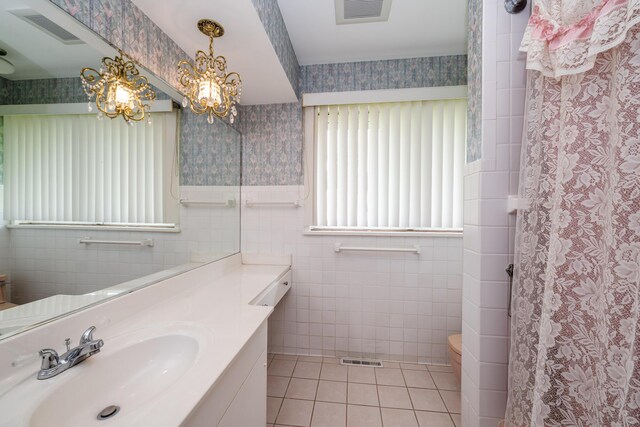 2310 Riverbend Dr, Benton Harbor, MI 49022 - bathroom with tile walls, toilet, wallpapered walls, tile patterned floors, and vanity