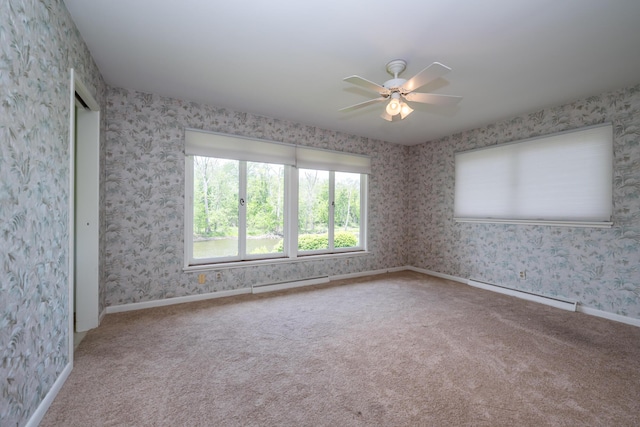 2310 Riverbend Dr, Benton Harbor, MI 49022 - carpeted empty room featuring a baseboard heating unit, ceiling fan, wallpapered walls, and baseboards