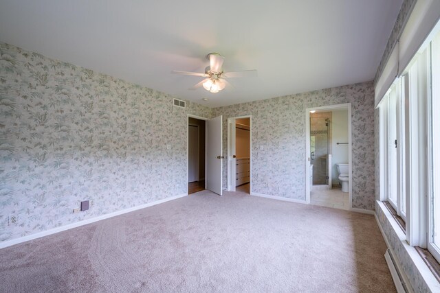 2310 Riverbend Dr, Benton Harbor, MI 49022 - unfurnished bedroom with wallpapered walls, carpet floors, ceiling fan, baseboard heating, and ensuite bathroom