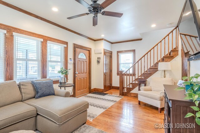 1836 Silver Ave SE, Grand Rapids, MI 49507 - living room with stairs, light wood-style flooring, a ceiling fan, ornamental molding, and baseboards