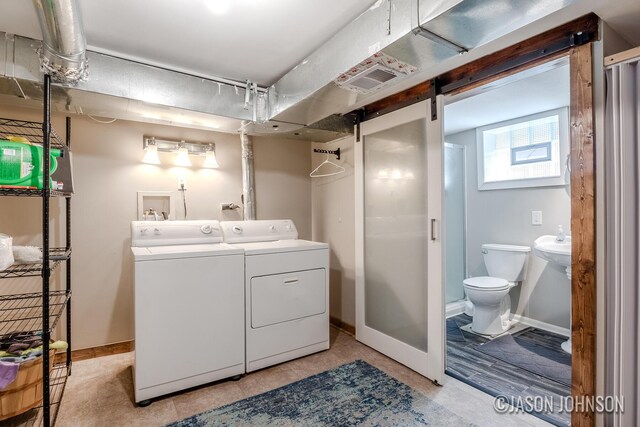 1836 Silver Ave SE, Grand Rapids, MI 49507 - laundry room with washing machine and clothes dryer, baseboards, and a barn door