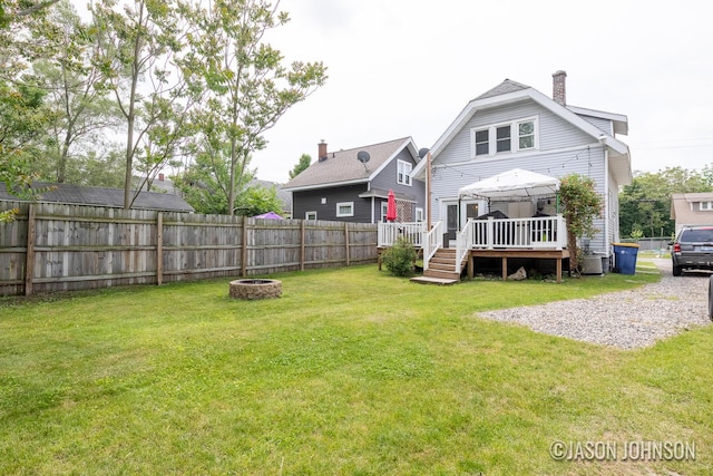 1836 Silver Ave SE, Grand Rapids, MI 49507 - back of property with a wooden deck, a chimney, and a fire pit