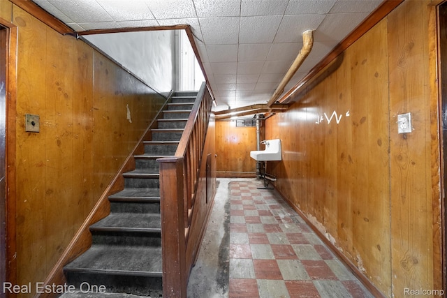 326 W Iroquois Rd, Pontiac, MI 48341 - staircase with tile patterned floors, wood walls, and baseboards