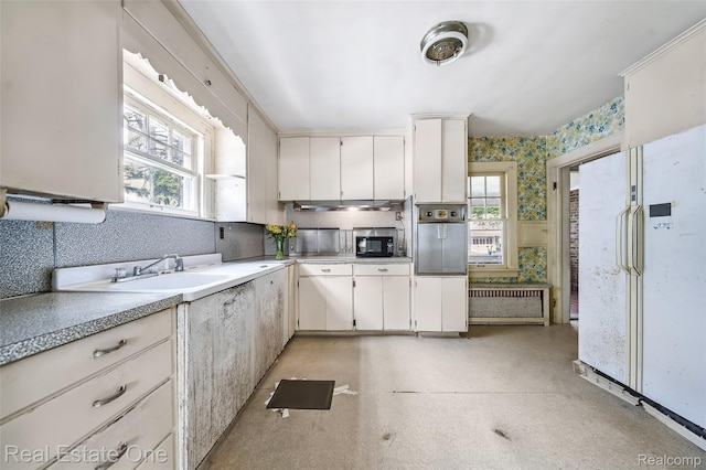 326 W Iroquois Rd, Pontiac, MI 48341 - kitchen with wall oven, plenty of natural light, freestanding refrigerator, light countertops, and wallpapered walls
