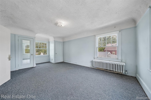 326 W Iroquois Rd, Pontiac, MI 48341 - empty room with radiator heating unit, carpet floors, a textured ceiling, and baseboards