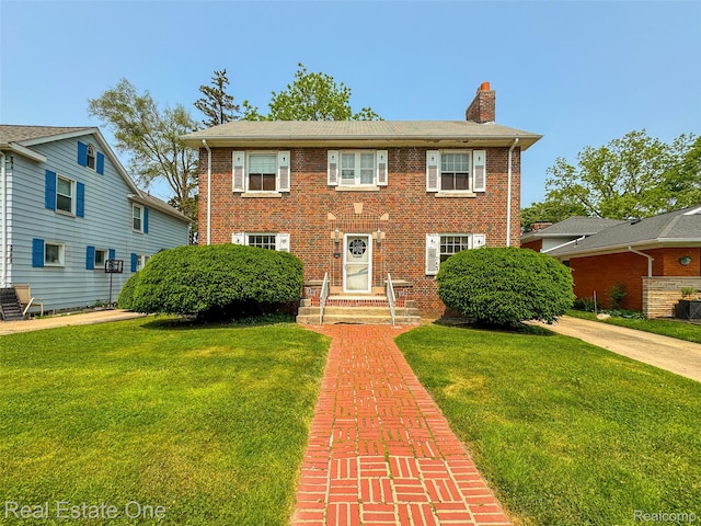 326 W Iroquois Rd, Pontiac, MI 48341 - colonial home with a chimney, a front yard, and brick siding