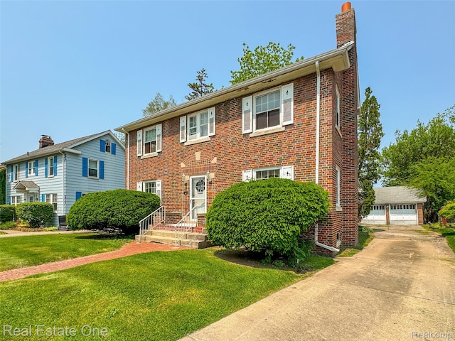 326 W Iroquois Rd, Pontiac, MI 48341 - view of front of home featuring a chimney, a front yard, brick siding, and an outbuilding