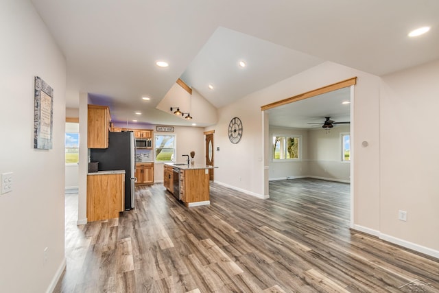 6835 Hackett Rd, Freeland, MI 48623 - kitchen with open floor plan, dark wood finished floors, an island with sink, appliances with stainless steel finishes, and light countertops