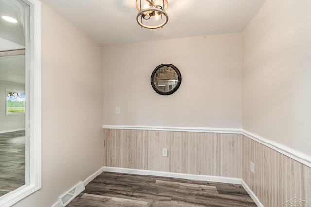 6835 Hackett Rd, Freeland, MI 48623 - empty room with wainscoting, dark wood finished floors, and a chandelier