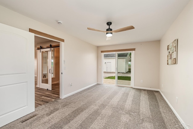 6835 Hackett Rd, Freeland, MI 48623 - carpeted spare room with ceiling fan, a smoke detector, and a barn door