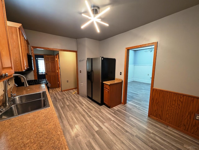 208 State St, Bay City, MI 48706 - kitchen featuring a sink, refrigerator with ice dispenser, gas range, light wood-type flooring, and a wainscoted wall