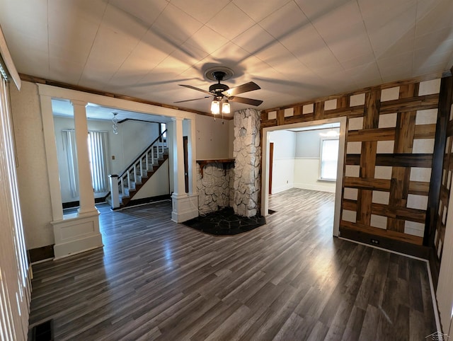 208 State St, Bay City, MI 48706 - unfurnished living room featuring decorative columns, dark wood-style flooring, ceiling fan, stairway, and baseboards