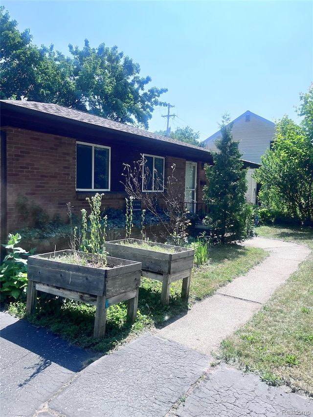140 Pershing Dr NE, Grand Rapids, MI 49505 - view of front of house with a garden and brick siding