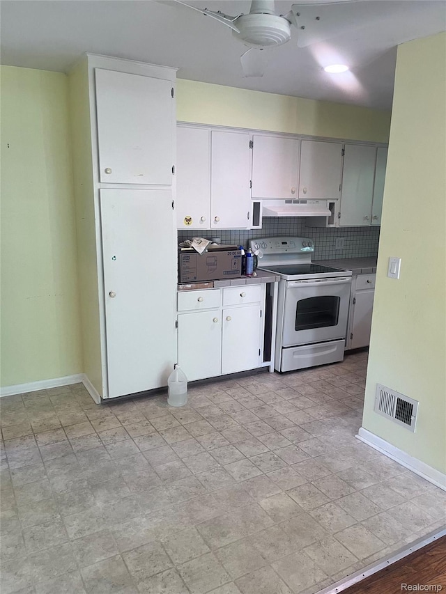 140 Pershing Dr NE, Grand Rapids, MI 49505 - kitchen with white electric range oven, under cabinet range hood, backsplash, and white cabinetry