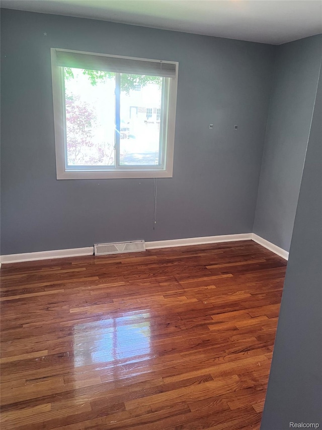140 Pershing Dr NE, Grand Rapids, MI 49505 - empty room with healthy amount of natural light and wood finished floors