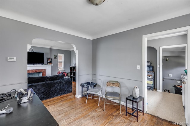 19200 Goulburn St, Detroit, MI 48205 - interior space with arched walkways, a brick fireplace, wood finished floors, and baseboards
