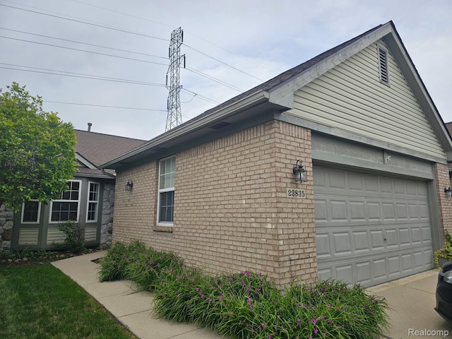 22835 Woodcreek Dr Unit 32, Taylor, MI 48180 - view of home's exterior with brick siding, a garage, and driveway