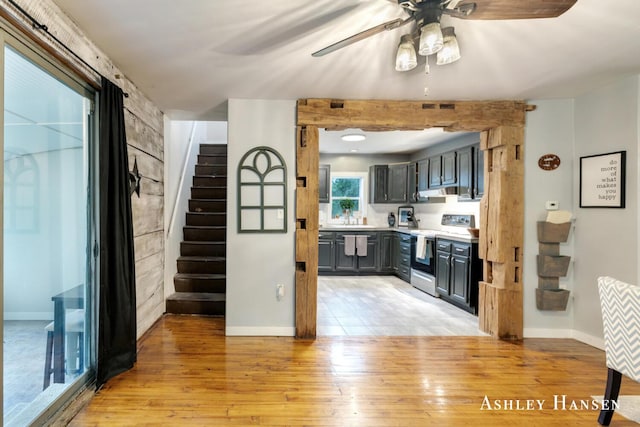 12577 Redmond Ave NE, Cedar Springs, MI 49319 - kitchen with stainless steel electric range, light wood-type flooring, a ceiling fan, baseboards, and light countertops