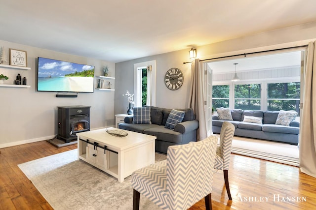 12577 Redmond Ave NE, Cedar Springs, MI 49319 - living area with a wood stove, light wood finished floors, and baseboards