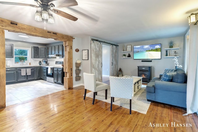 12577 Redmond Ave NE, Cedar Springs, MI 49319 - living room featuring a barn door, light wood-type flooring, and ceiling fan