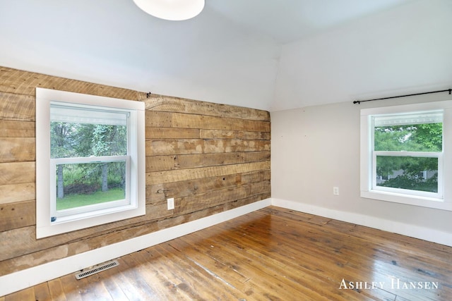 12577 Redmond Ave NE, Cedar Springs, MI 49319 - unfurnished room featuring healthy amount of natural light, wood walls, lofted ceiling, and wood-type flooring