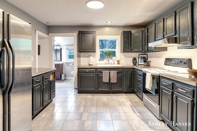 12577 Redmond Ave NE, Cedar Springs, MI 49319 - kitchen with stainless steel fridge, electric range oven, a sink, under cabinet range hood, and tasteful backsplash