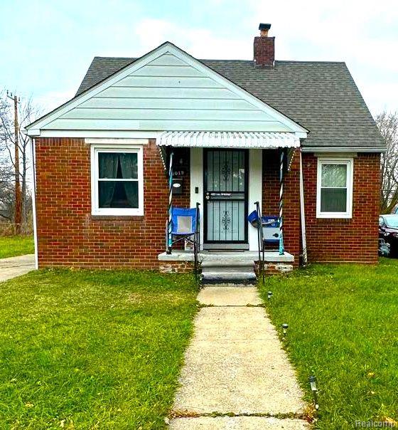 16019 E State Fair St, Detroit, MI 48205 - bungalow with a front lawn, brick siding, a chimney, and roof with shingles