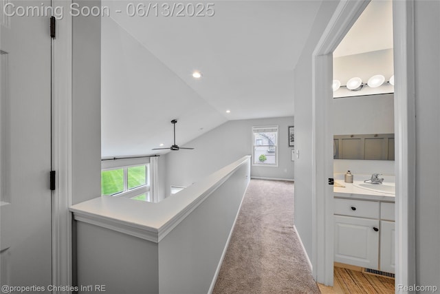 9840 Oak Valley Dr, Clarkston, MI 48348 - hallway with a sink, lofted ceiling, plenty of natural light, light colored carpet, and an upstairs landing