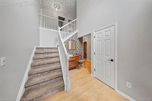 9840 Oak Valley Dr, Clarkston, MI 48348 - stairs featuring a towering ceiling, wood finished floors, and baseboards