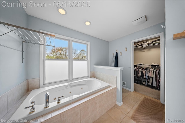 9840 Oak Valley Dr, Clarkston, MI 48348 - bathroom featuring a tub with jets, tile patterned floors, a spacious closet, and baseboards