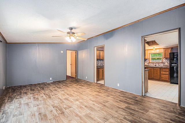 67173 Bulhand Rd, Cassopolis, MI 49031 - empty room with light wood-type flooring, a ceiling fan, crown molding, and a textured ceiling