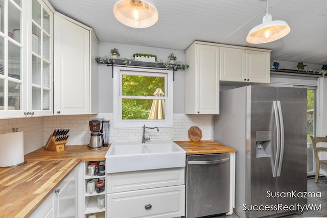111 W 1st Ave, Plainwell, MI 49080 - kitchen featuring appliances with stainless steel finishes, a sink, butcher block counters, and decorative backsplash