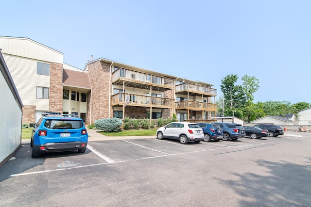 855 S Pontiac Trl Unit A305, Walled Lake, MI 48390 - view of apartment building / complex with uncovered parking