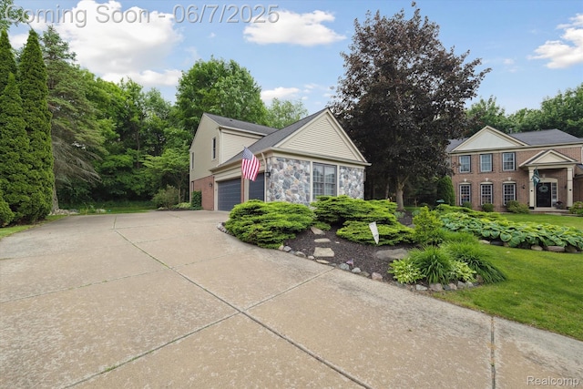 3753 Rolling Hills Rd, Lake Orion, MI 48359 - view of front of home with driveway, an attached garage, a front yard, stone siding, and brick siding