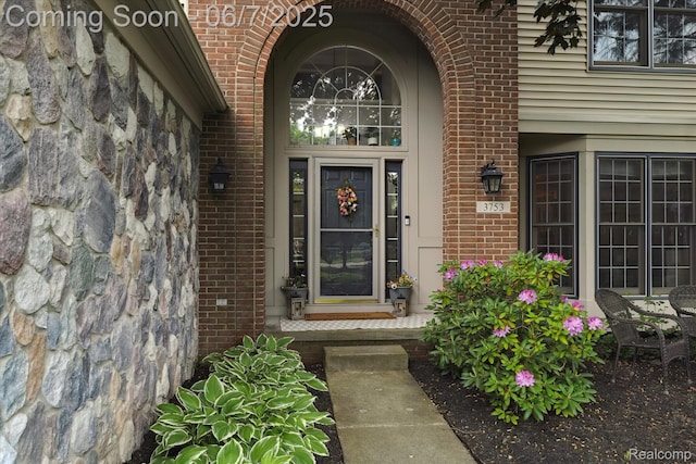 3753 Rolling Hills Rd, Lake Orion, MI 48359 - doorway to property with brick siding, stone siding, and a porch