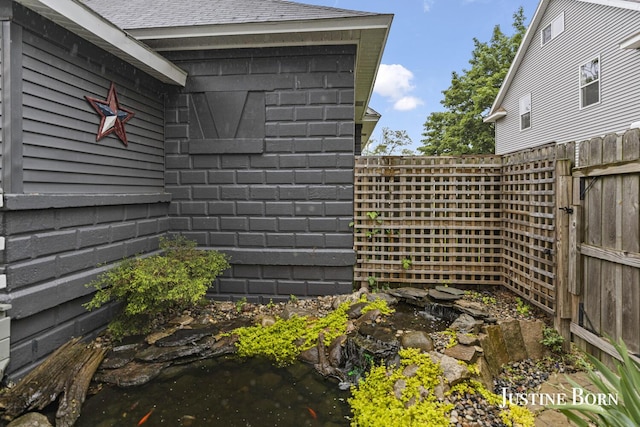 2264 Stafford Ave SW, Grand Rapids, MI 49507 - view of property exterior featuring a small pond and roof with shingles