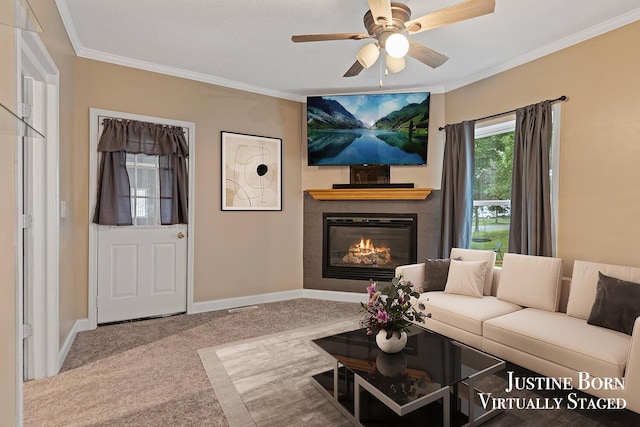 2264 Stafford Ave SW, Grand Rapids, MI 49507 - carpeted living room featuring a tiled fireplace, ornamental molding, ceiling fan, and baseboards