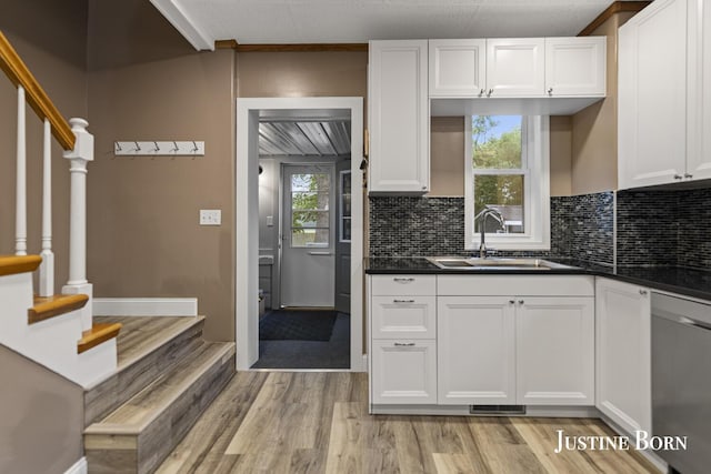 2264 Stafford Ave SW, Grand Rapids, MI 49507 - kitchen featuring a sink, dishwasher, light wood-style floors, and white cabinetry