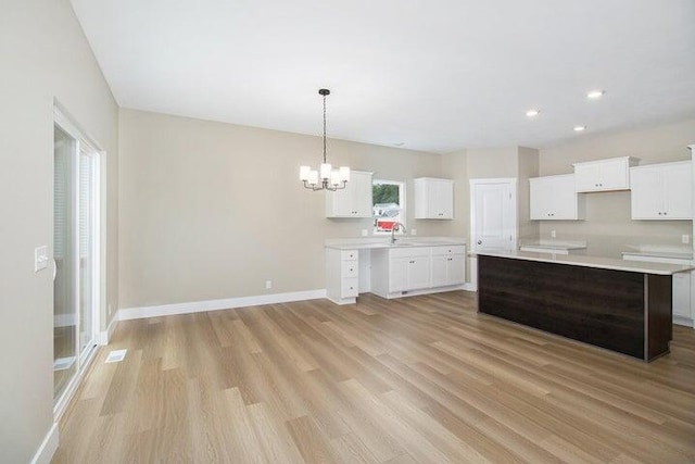 6218 Sturgeon Run, Muskegon, MI 49444 - kitchen featuring light wood finished floors, a chandelier, baseboards, white cabinetry, and recessed lighting